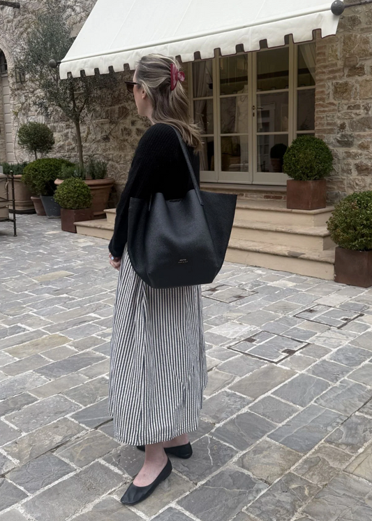 ALVEA black leather tote carried outdoors